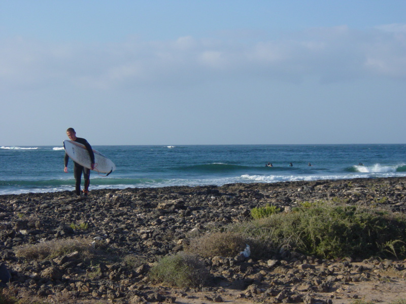Surfer on the rocky beach at Majanichio inside, Fuerteventura.