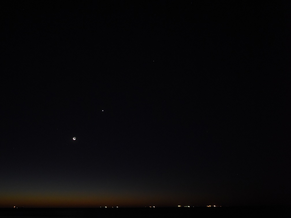 Maan, Venus, Saturnus en Jupiter boven de oceaan