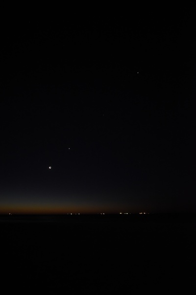 Maan, Venus, Saturnus en Jupiter boven de oceaan
